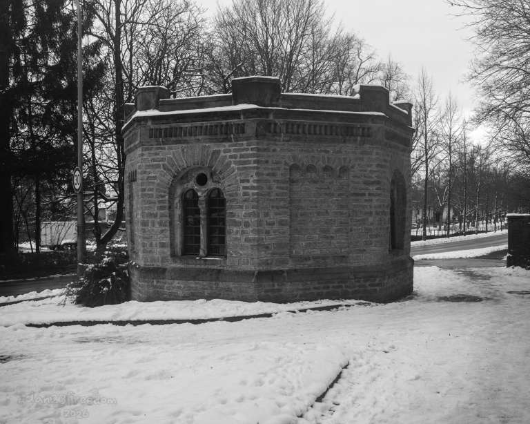There is a dignified mystery to this structure, nestled deeply within the snowy stillness. The intricate details of the stone contrast with the soft, white silence, evoking the feeling of a secret kept by history. Whether a sanctuary or a meeting place for those who call forth the winter, the image captures a perfect balance of architectural grit and peaceful calm.